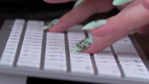 Τα δάχτυλα μιας νεαρής κοπέλας δακτυλογραφούν στο πληκτρολόγιο ενός Λευκού Φορητού — Αρχείο Βίντεο