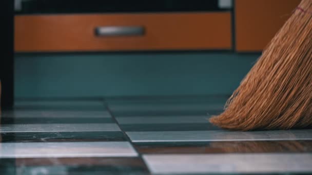 Jong meisje veegt de vloer in de keuken met een gewone bezem — Stockvideo