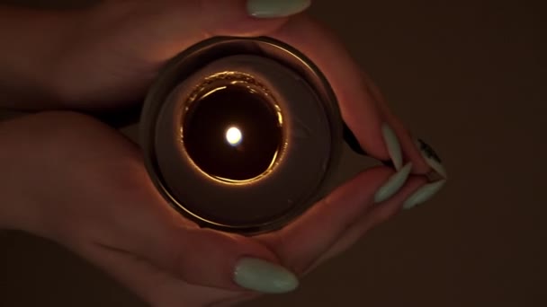 Свічка горить на сонці в руках дівчини з чудовою манерою — стокове відео