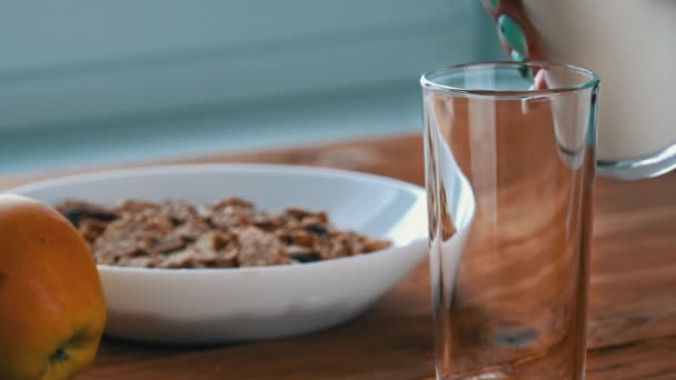 Milch in ein Glas zum Frühstück mit Haferflocken in Slow Mo gießen — Stockvideo