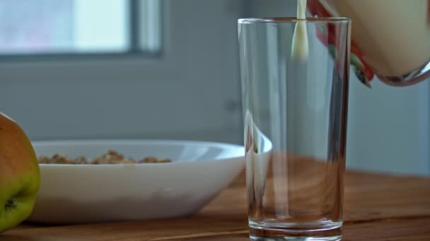 Häll mjölk i ett glas till frukost med havregryn i Slow Mo — Stockvideo