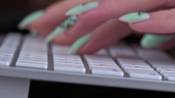 Dedos de uma jovem estão digitando no teclado de um laptop branco — Vídeo de Stock