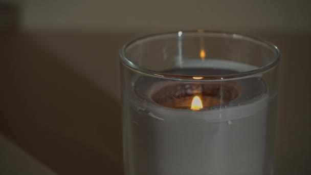 Atmosfericamente, uma vela queima, emitindo sua própria sombra na noite — Vídeo de Stock