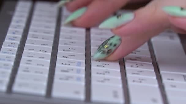 Los dedos de una chica joven están escribiendo en el teclado de un portátil blanco — Vídeo de stock