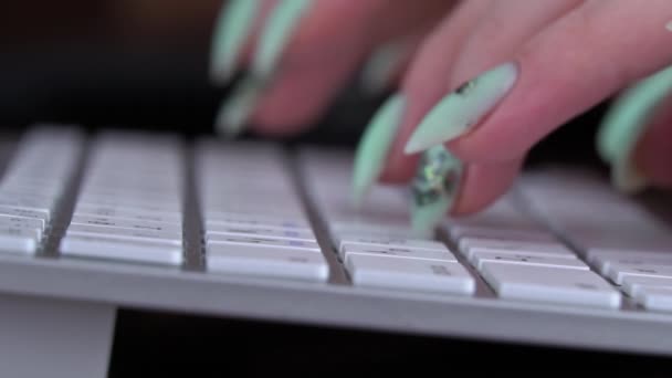 Fingrarna på en ung flicka skriver på tangentbordet på en vit laptop — Stockvideo