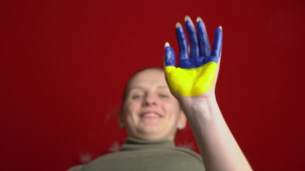 Mão de uma menina com a bandeira da Ucrânia pede para parar a guerra — Vídeo de Stock