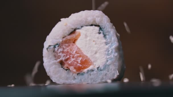 Las semillas de sésamo se vierten en un rollo de sushi fresco en Slow-mo Close-up — Vídeos de Stock