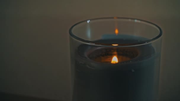 Atmosphärisch brennt eine Kerze, die am Abend ihren eigenen Schatten wirft — Stockvideo