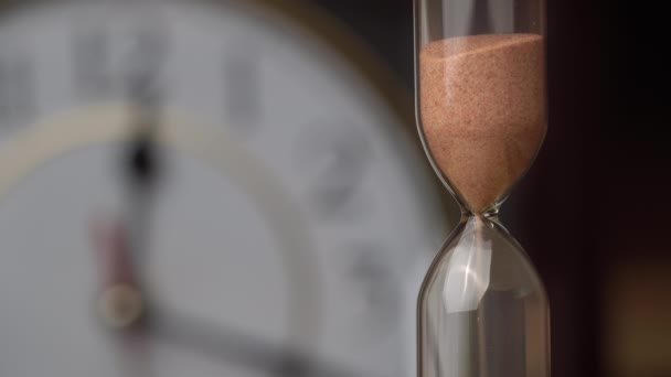 Zandloper Close-up giet tegen de achtergrond gewoon mechanisch horloge — Stockvideo