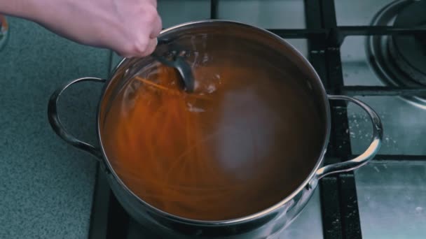 Ženské ruce Míchat špagety v pánev s vroucí vodou Pomalá Mo — Stock video