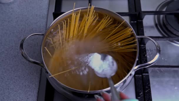 Női kéz keverjük spagetti egy csészealj forrásban lévő víz lassú Mo — Stock videók