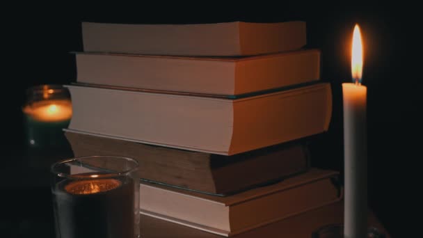 Pila di libri a lume di candela, una selezione di letteratura per la lettura di notte — Video Stock