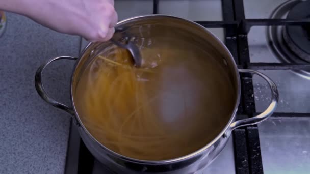 Ženské ruce Míchat špagety v pánev s vroucí vodou Pomalá Mo — Stock video