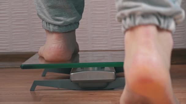 Жіночі ноги стоять на вагах і перевіряють їх кілограми Назад Перегляд — стокове відео