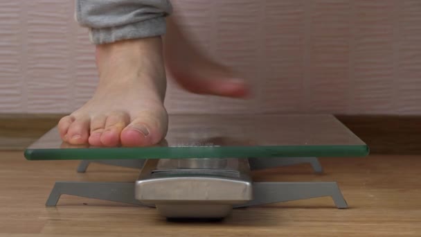 Frauenfüße stehen auf der Waage und prüfen ihre Kilogramm Vorderansicht — Stockvideo