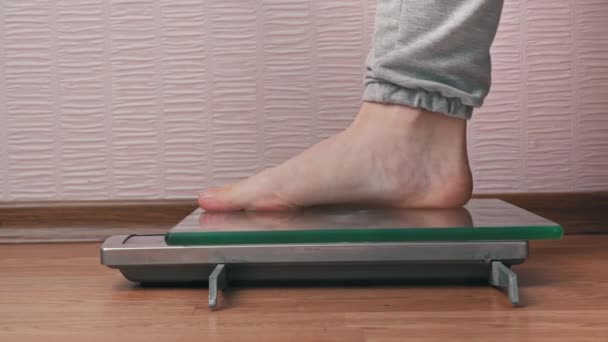Женские ноги стоять на весах и проверить свои килограммы боковой вид — стоковое видео