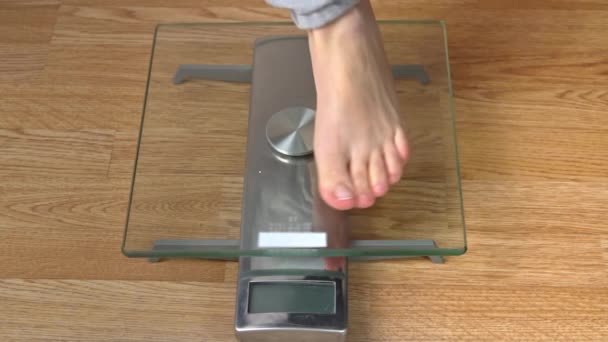 I piedi delle donne stanno sulle scale e controllano i loro chilogrammi Top View — Video Stock