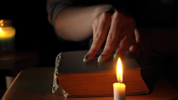 Girl by Candlelight abre y lee un libro antiguo por la noche — Vídeo de stock