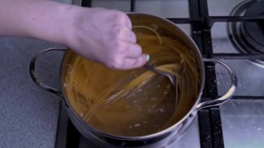 Kadın Elleri Spaghetti 'yi kaynayan suyla karıştırır