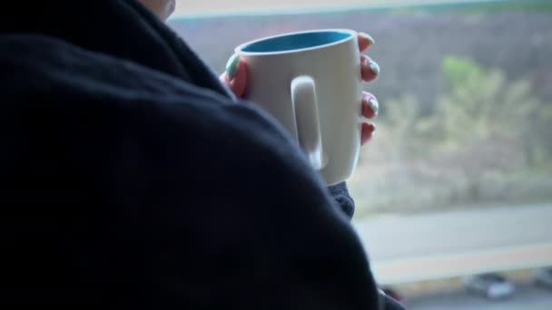 Donna beve caffè da tazza in accappatoio nero a una finestra aperta al mattino — Video Stock