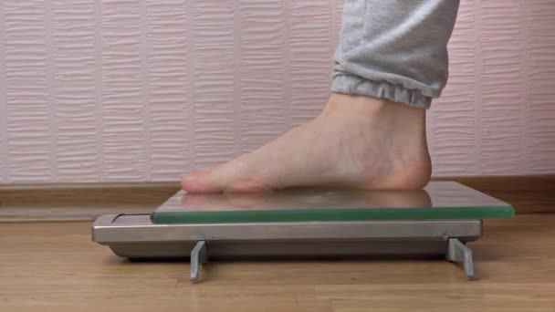 Piedi Donna Stand sulla bilancia e controllare i loro chilogrammi vista laterale — Video Stock