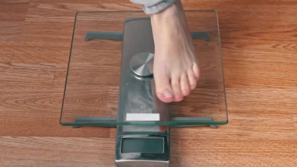 I piedi delle donne stanno sulle scale e controllano i loro chilogrammi Top View — Video Stock