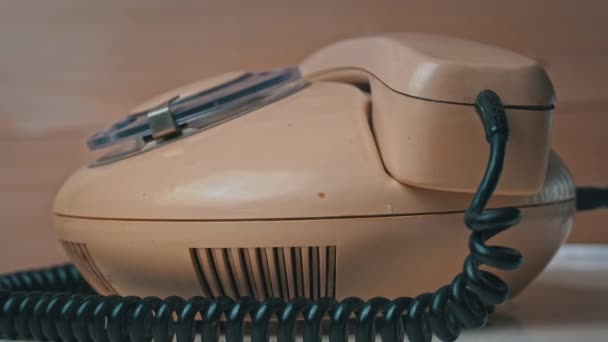 女性の手は、古いヴィンテージ有線電話とコールの受信機を拾う — ストック動画