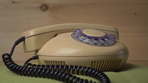 Le vieux téléphone filaire domestique tourne sur un fond en bois — Video