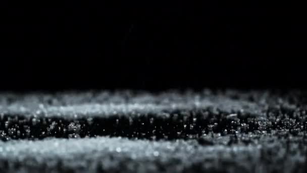 White Granulated Sugar Pours Onto a Black Glass Surface Creating a Slide — Stock Video