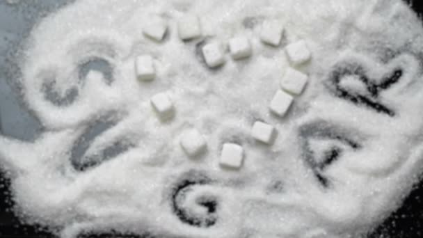 Cubetti di zucchero bianco a forma di cuore sdraiati sulla sabbia di zucchero — Video Stock