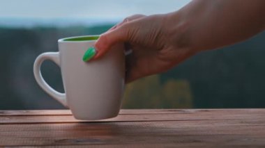 Bir fincan sıcak çay ya da kahve Açık Pencere kenarında durur ve buhar çıkarır.