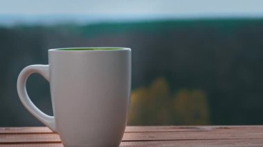 Bir fincan sıcak çay ya da kahve Açık Pencere kenarında durur ve buhar çıkarır.