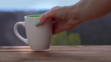 Bir fincan sıcak çay ya da kahve Açık Pencere kenarında durur ve buhar çıkarır.