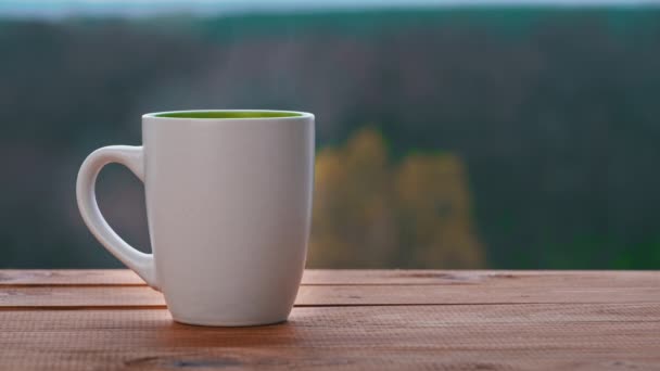Tazza di tè caldo o tavolini da caffè da una finestra aperta ed emette vapore — Video Stock