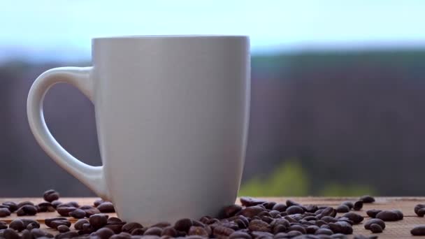 Tazza di caffè caldo stand dalla finestra aperta e rilascia vapore contro il cielo — Video Stock