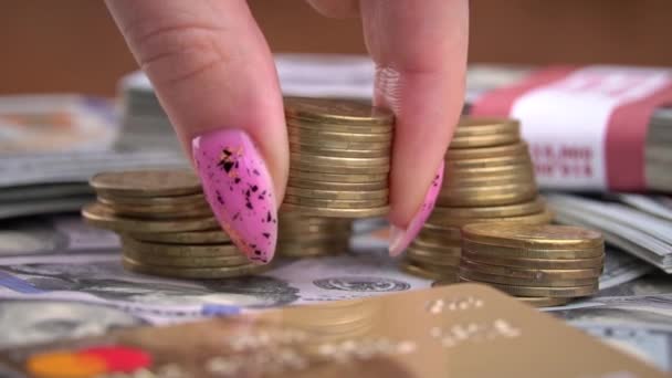 Flicka räknar mynt på bakgrunden av hundra dollarsedlar — Stockvideo