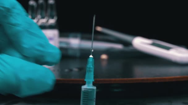 Sjuksköterska förbereder en spruta och medicin droppar från det i stora droppar närbild — Stockvideo