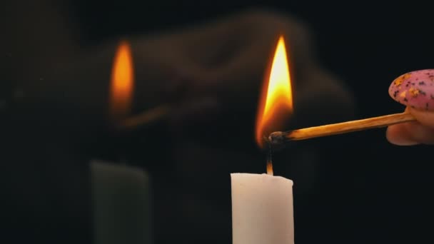 White Paraffin Candle is Lit with a Match on a Black Background in Reflection — Stok Video