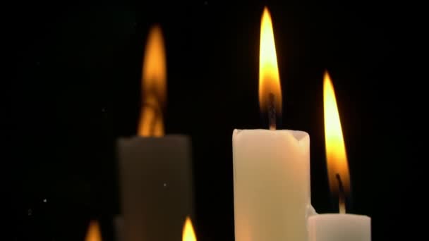 White Paraffin Candles with a Yellow Tint Burn on Black Background in Reflection — Stock Video