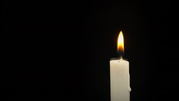 White Paraffin Candle with Yellow Tints Burns on Black Background in Reflection — Vídeo de stock