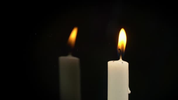 White Paraffin Candle with Yellow Tints Burns on Black Background in Reflection — Vídeo de stock