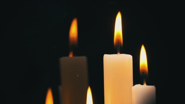 White Paraffin Candles with a Yellow Tint Burn on Black Background in Reflection — Video