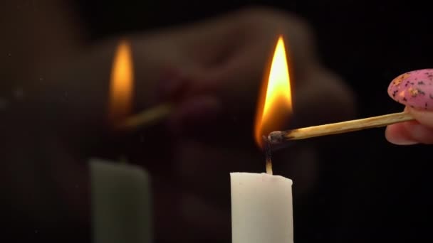 White Paraffin Candle is Lit with a Match on a Black Background in Reflection — Stockvideo