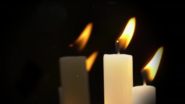 White Paraffin Candles with a Yellow Tint Burn on Black Background in Reflection — Vídeo de stock