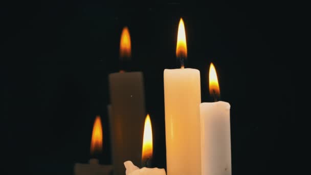 White Paraffin Candles with a Yellow Tint Burn on Black Background in Reflection — Vídeo de stock