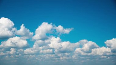 White Fluffy Clouds Slowly Float Through the Blue Daytime Sky Timelapse