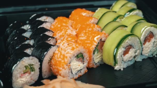 寿司在纺盘上打滚 餐厅里有寿司日本料理 寿司卷鲑鱼和蔬菜 日本餐馆菜单 侧视图 — 图库视频影像