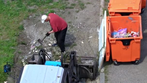 Een Man Met Een Schop Laadt Afval Een Tractor Tank — Stockvideo