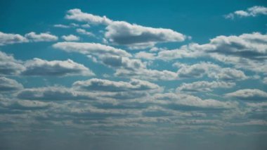 Beyaz kabarık bulutlar mavi gündüz vakti gökyüzünde yavaşça süzülür. Güzel gökyüzü hareket ediyor. Kar beyazı bulutlar yana doğru hareket ediyor..