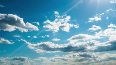 Beyaz kabarık bulutlar mavi gündüz vakti gökyüzünde yavaşça süzülür. Güzel gökyüzü hareket ediyor. Kar beyazı bulutlar yana doğru hareket ediyor..